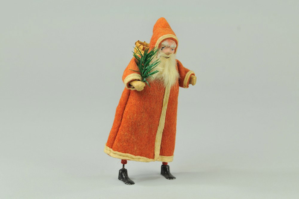 CLOCKWORK SANTA CLAUS WALKER: Germany, composition face, hand painted, lead feet, depicted in full red felt suit, white basket over shoulder, great action when clockwork is activated. 10 1/4" h. Minor chip at eye. (Exc. Cond.) 10 