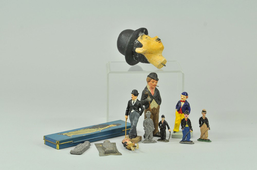 ASSORTED CHARLIE CHAPLIN ITEMS: Grouping features Charlie Chaplin pencil box, lead figure from France, composition figure with toothpick holes at head, large composition head to fit missing cloth puppet body, lead figures and early 