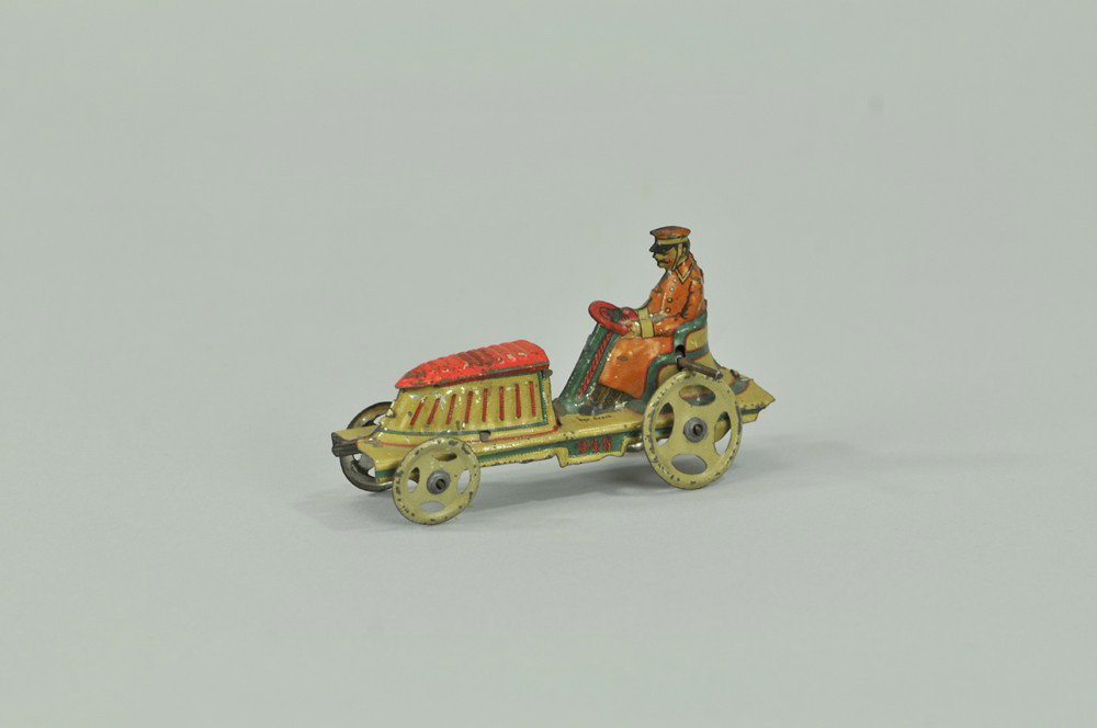 OPEN AUTO PENNY TOY: Meier, Germany, lithographed tin, seated driver, long bonnet done in red top, white and blue body, spoke wheels, this one sold with fly wheel. 3 5/8" l. (VG Cond) 3 5/8" l.