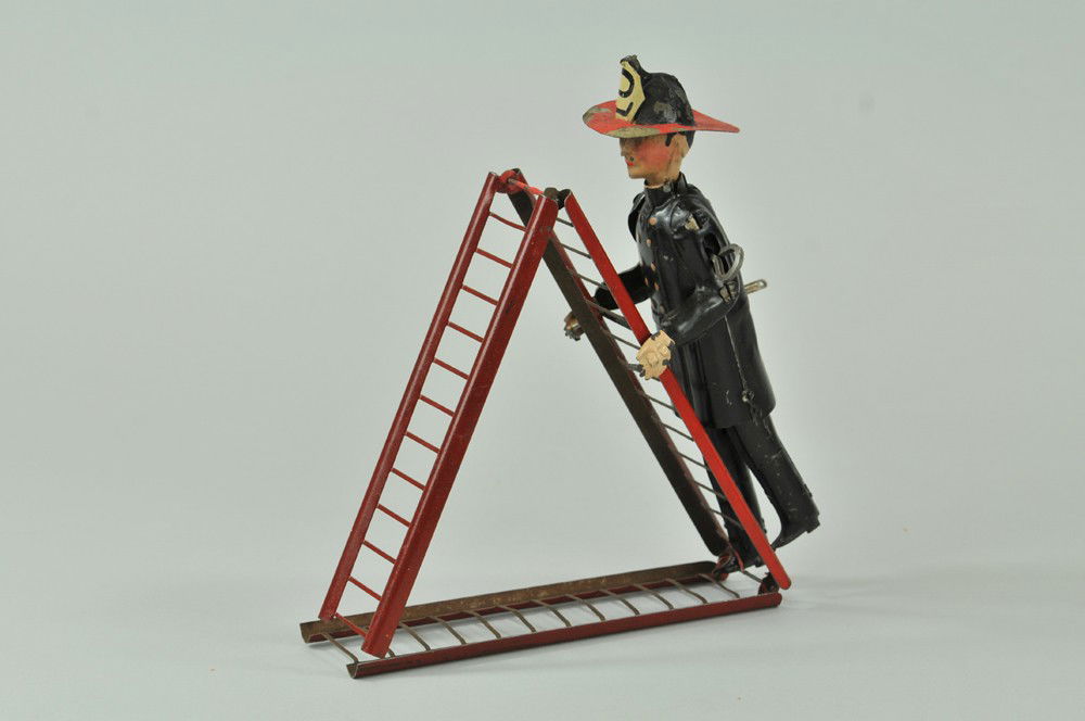FERNAND MARTIN CLIMBING FIREMAN: France, tin figure wearing full outfit and fire helmet appears to climb a tin tri-fold ladder with outstretched hands, quite ingenious mechanical action. 8" h. Repaint to hat, face and rung of ladder.