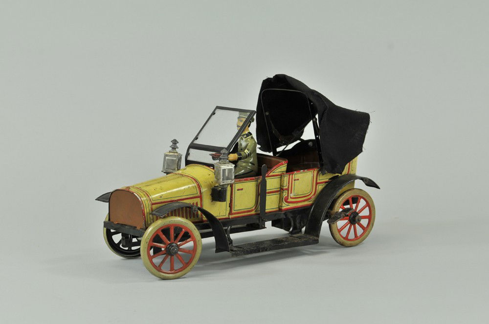 CARETTE DOUBLE PHAETON: c. 1906, lithographed tin, well styled and detailed with foldable canvas top, open chauffeur's seat, bright yellow body with red trim, spoke wheels, high style wind screen, clockwork driven, a visuall