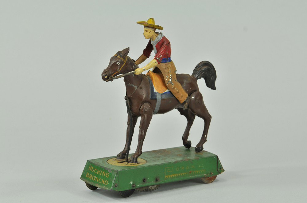 LEHMANN WILD WEST BUCKING BRONCO: Germany, brown horse version, lithographed and hand painted tin, features cowboy mounted on horse, clockwork mechanism allows wild bucking actions throwing cowboy off horse. 6 1/4" l. Paint worn, espe