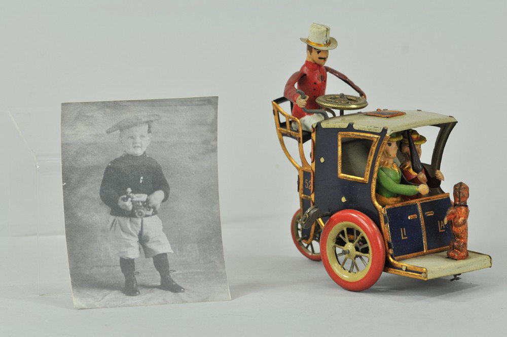 LEHMANN "LI LA" HANSOM CAB: Germany, lithographed and hand painted tin, coach, driver seated at rear roof of cab holding two seated ladies and dog by footrest, clockwork action also includes woman putting umbrella through trap d