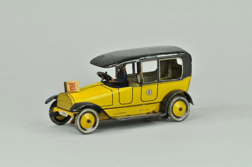 LEHMANN TAXI CAB: Germany, c. 1930's, lithographed tin, yellow body, black roof and running boards, features hood flag and taxi meter on side, seated driver, clockwork driven. 7" l. Touch up to fenders and roof. (VG Co