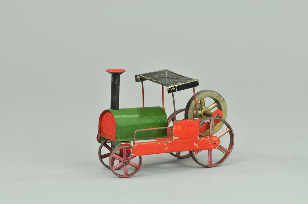 FERNAND MARTIN FLOOR TRAIN: France, hand-painted tin, steam type locomotive with rear flywheel propulsion, done in bright red and green, features canopy roof, very rare example. 5 3/4" l. Wear to paint at roof, overall (Exc. Con