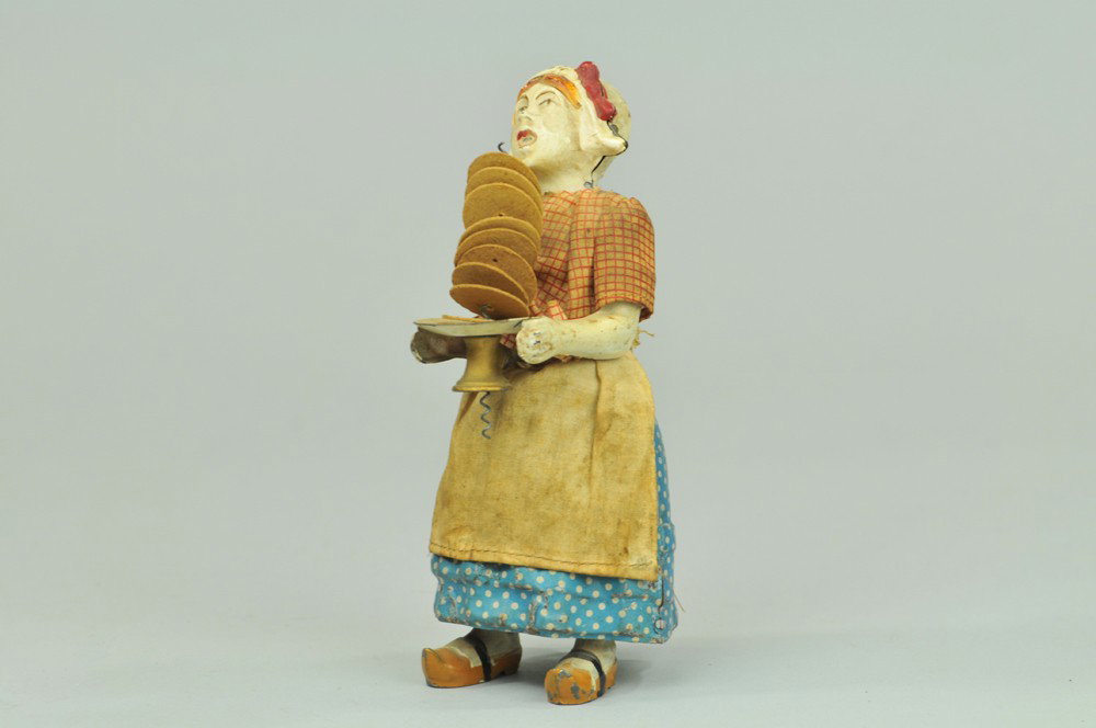 MARTIN MAID CARRYING DISHES: France, an amusing depiction of a woman holding a stack of dishes in hand, spring activates a calamity of falling plates, very ingenious design. 7 3/4" h, Dishes are paper replacements, repaint to fac