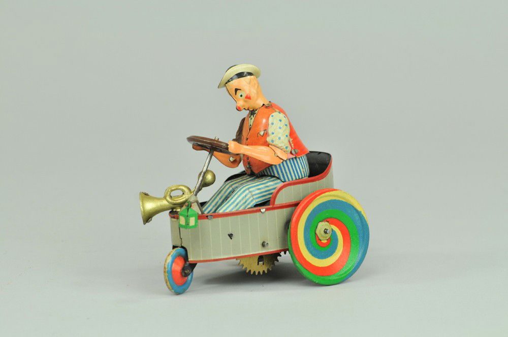 LEHMANN "PETER" MIXTUM AUTO: Germany, lithographed tin, another heap of scrap auto, as it was billed, featuring white driver, horn and lantern at front of tub shaped auto, colorful and amusing, clockwork driven. 4 1/2" l. (Exc. C