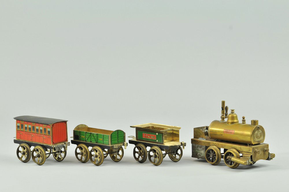 VULKAN STEAM POWERED ERNST PLANK TRAIN SET: Brass locomotive 0-4-0 with lithographed four wheel tender, together with green gondola and red coach, wide wheel base makes an almost fantasy gauge, spoke wheels. 4 1/4" l. NOTE: Engine is missing st