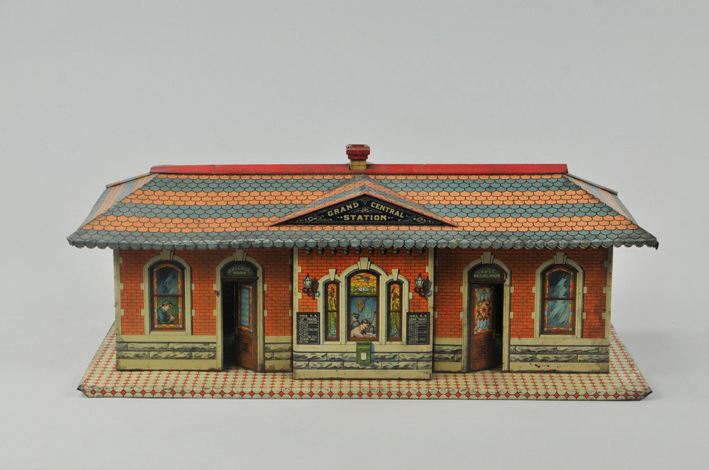 IVES "GRAND CENTRAL"STATION: Large tin building accessory, well detailed lithography with extensive graphic portrayal of brick train station, people at windows, depicts open front doors. 22" l. Bend at roof trim, overall (VG Cond