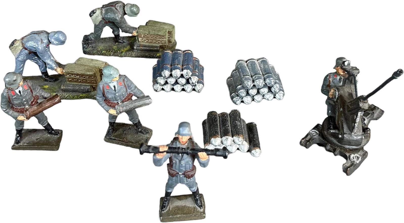 LINEOL LUFTWAFFE ARTILLERY FIGURES: 113. LINEOL LUFTWAFFE ARTILLERY FIGURES | 9 pieces total to include 5 Luftwaffe gunners, 3 stacks of shells, plus an AA gun on revolving base. | 75mm | AA gun repaired, otherwise (Very Good Condition)