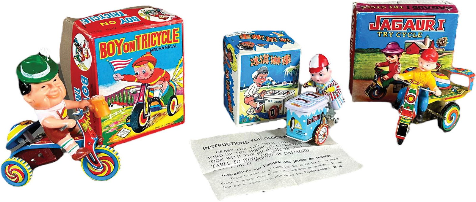 THREE BOXED WIND-UP TRIKES (1 of 5)