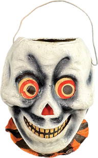 EXPRESSIVE SKULL HALLOWEEN LANTERN: 346. EXPRESSIVE SKULL HALLOWEEN LANTERN | Rare early German skull lantern with a black and orange crepe paper bow tie and whimsical expressive face. | 5"h | Original inserts with a tear to one eye, pr