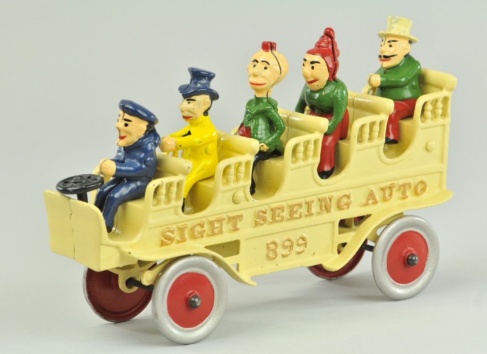 KENTON SIGHT SEEING BUS: Scarce and desirable cast iron bus toy, painted in white overall, embossed "SIGHT SEEING AUTO 899," features open benches with five seated comic character figures. 10 1/4" l.