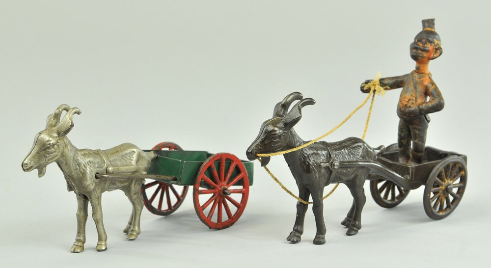 KENTON GOAT CARTS: Cast iron, both drawn by cast goats, one nickeled with pressed steel cart, one japanned with intregal cast wagon and Happy Hooligan standing on bed. 7 1/2" l.