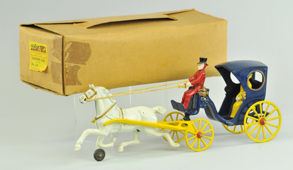 BOXED KENTON HANSOM CAB: Cast iron, painted in blue, seated driver, drawn by white horse w/bobbed tail, yellow spoke wheels. 15" l.