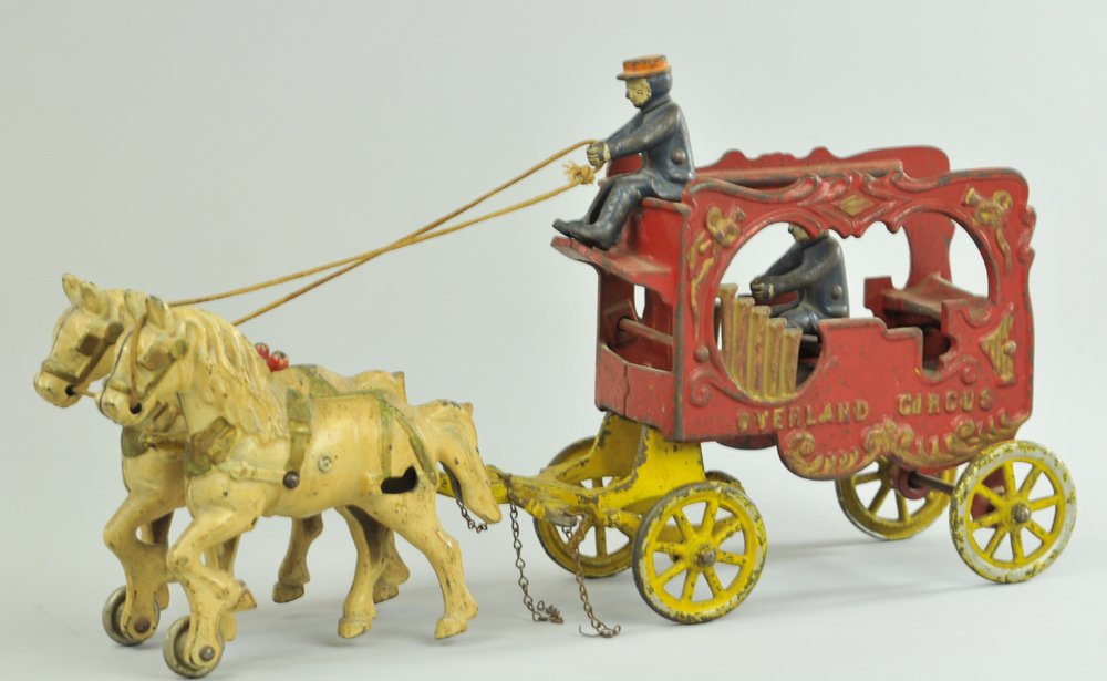 KENTON OVERLAND CIRCUS CALLIOPE: Cast iron, extensive mold designs to open music wagon, features pipe organ embossing on sides, rider and seated rider in wagon, yellow hitch, drawn by two white horses. 14" l.