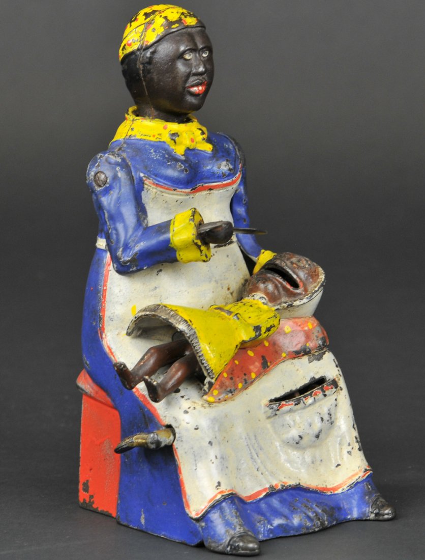 MAMMY & CHILD MECHANICAL BANK: Kyser & Rex Co., designed by Alfred C. Rex, patented 10/21/1884. Place a coin in the slot on the mammy’s apron and press the lever, the mammy lowers the spoon as if feeding the baby, her head lowers
