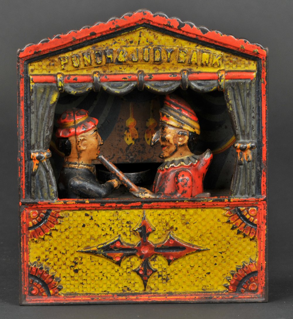 PUNCH & JUDY MECHANICAL BANK: Medium letters, Shepard Hardware Co., designed by Peter Adams & Charles Shepard, patented 7/15/1884. Judy receives the coin in the plate, the thumb piece at the side is pressed upon and Punch rushes f