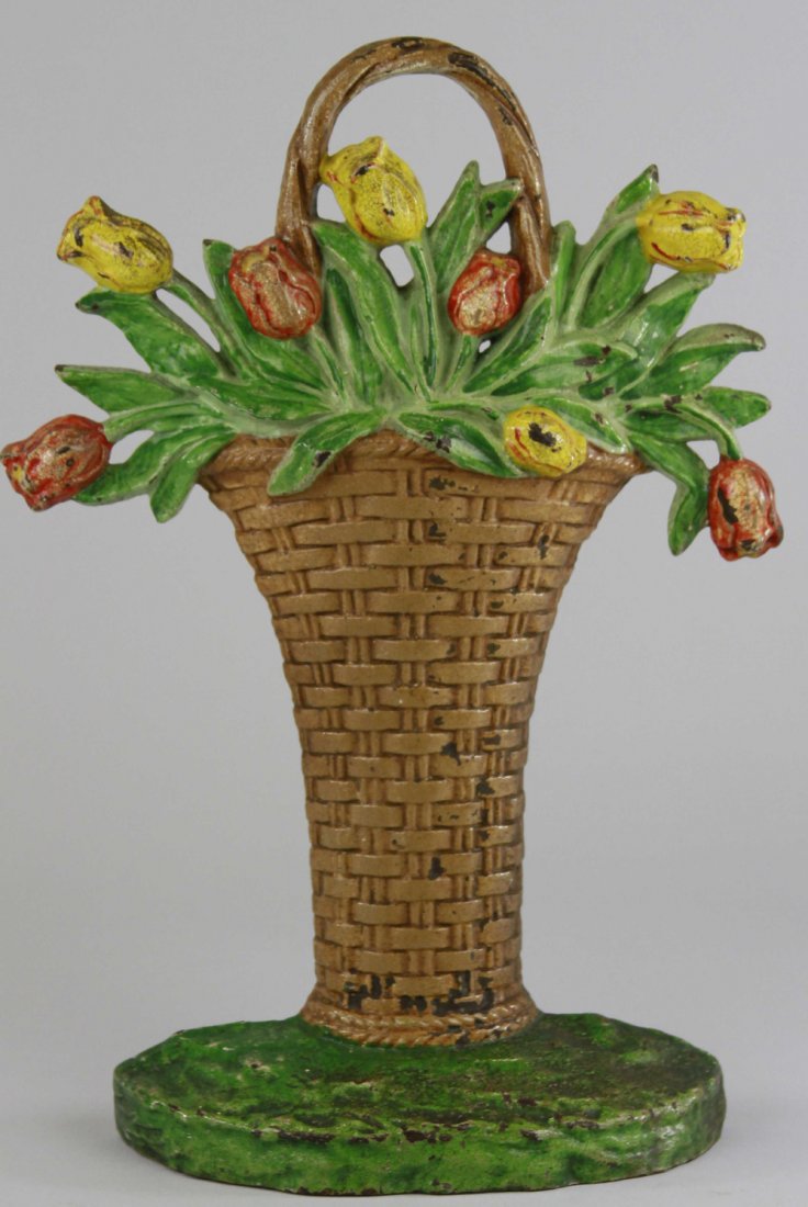 TULIPS IN BASKET DOORSTOP: Hubley, Cat. #86, tall wicker basket design painted brown, tulips done in red & yellow, green base, heavy casting. 13 1/8" x 9".