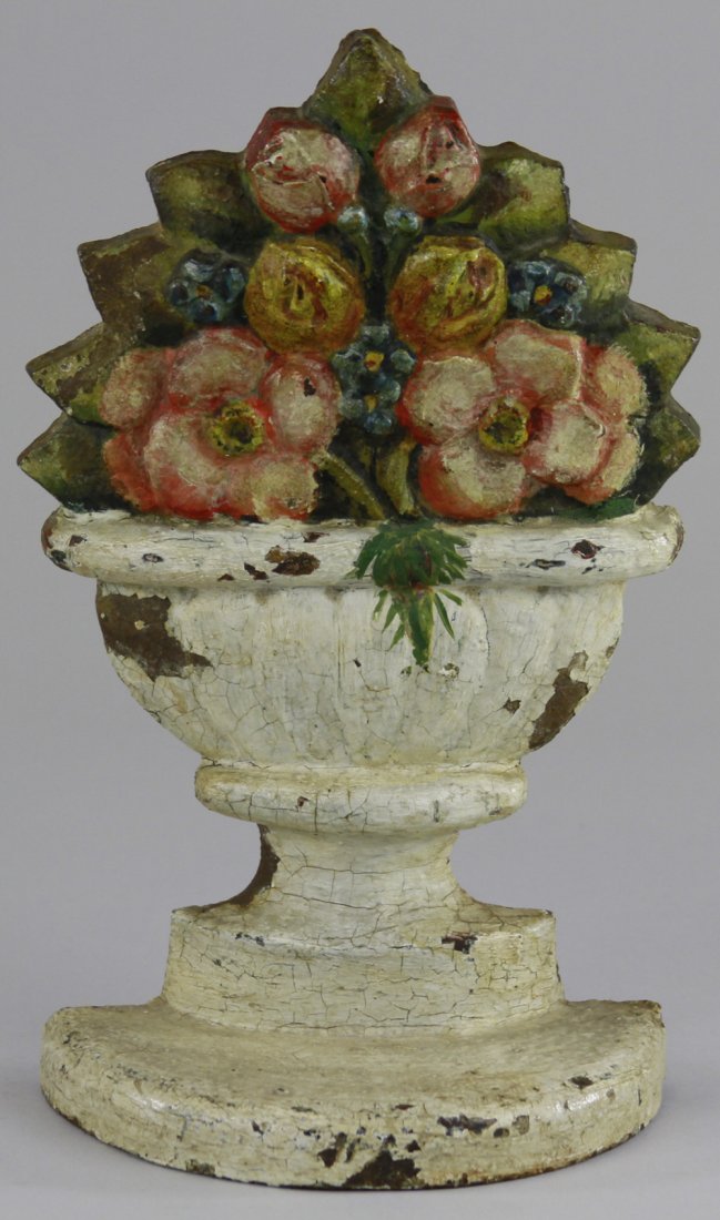 POPPIES IN URN DOORSTOP: Depicts light yellow, red, and orange flowers in white urn on base, very heavy & unusual, nice form. BOOK EXAMPLE. 9 1/4" x 5 5/8".