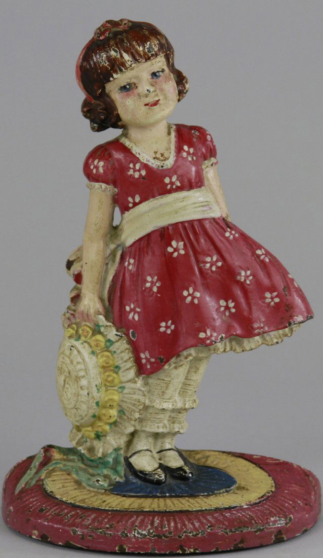 GIRL WITH BONNET DOORSTOP: "Pat app'd for," Trade (logo) mark. Waverly Studios, cast iron depiction of inquisitive, humbled girl on braided rug base holding oversized sun bonnet, wonderful theme. 8" 5 1/8".