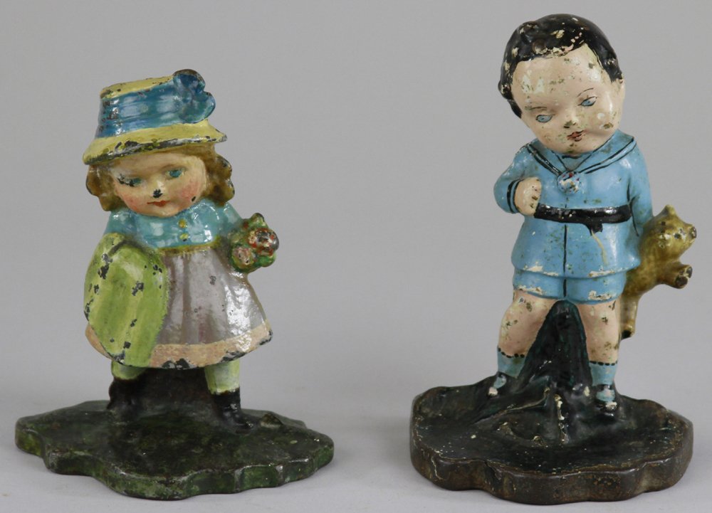 LOT OF TWO CHILD FIGURE DOORSTOPS: Children's doorstop depicting boy in school outfit holding teddy bear, along with girl in dress holding coat & flower bouquet, charming pieces. 5 1/2" - 6".