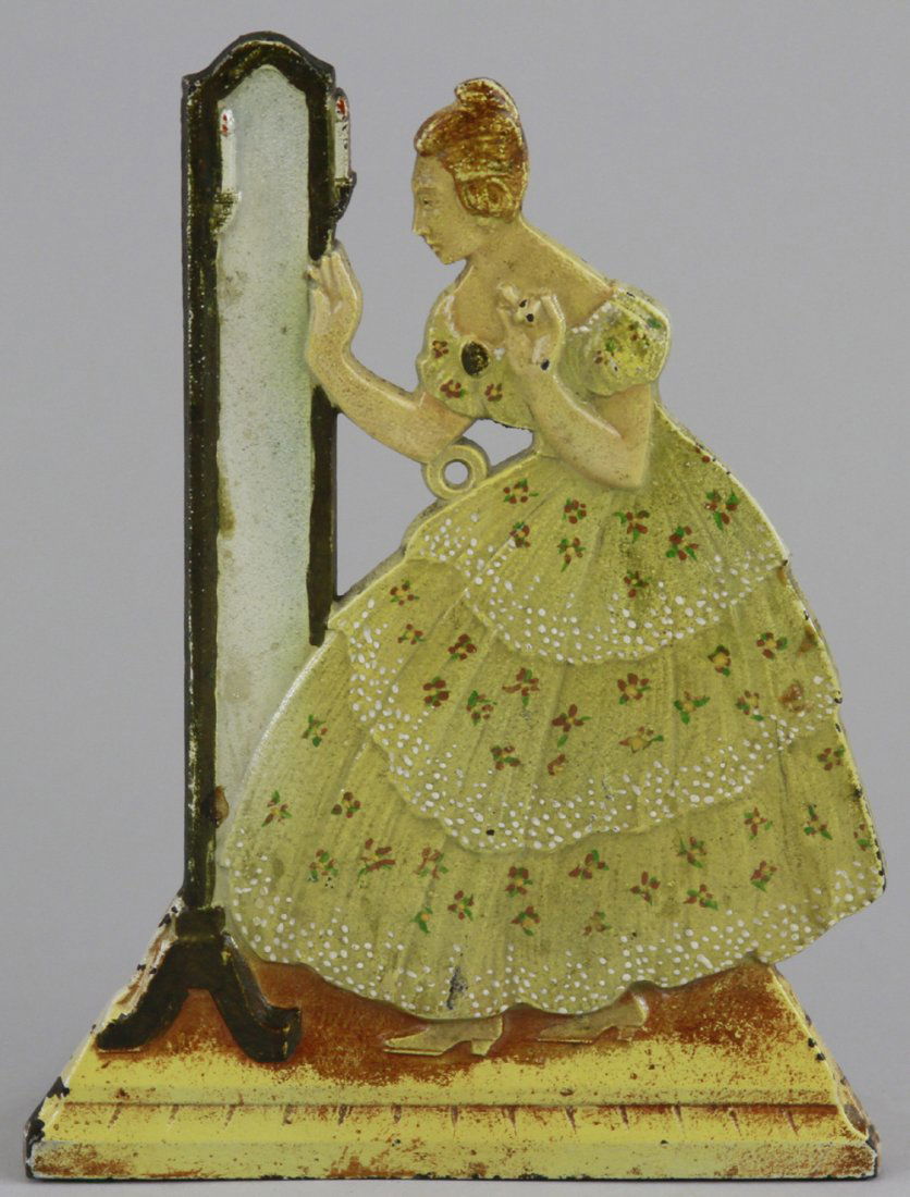 LADY AT MIRROR STRING HOLDER: Judd Co., rare and clever design, allows this cast iron piece to be used as a string holder. On reverse side, holds string w/small feed cast under woman's elbow for dispensing, woman in white ruffled