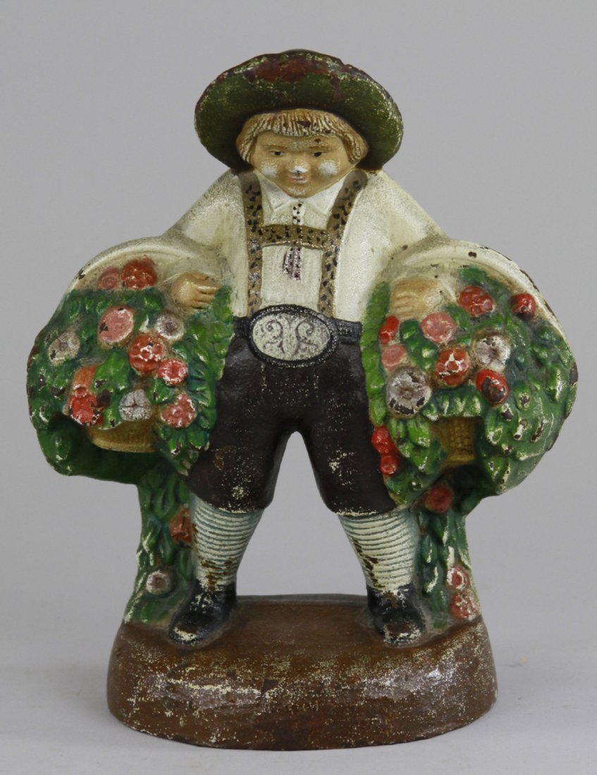 BOY IN LEDERHOSEN W/FLOWERS DOORSTOP: Judd Co., "1275," heavy casting, depicting rotund young man in regional dress carrying large baskets of flowers. BOOK EXAMPLE. 7 1/2" 5 3/4".