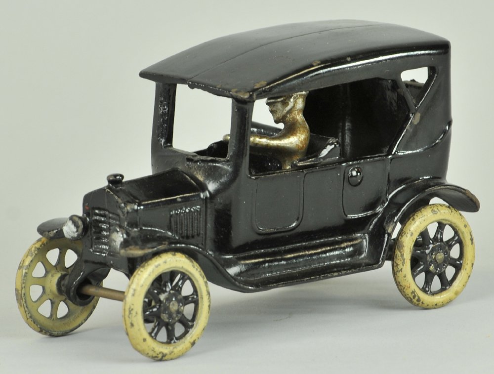 ARCADE MODEL "T" TOURING CAR: Cast iron, painted in black overall, simulated soft top model, spoke wheels, seated driver. 6 1/2" l.