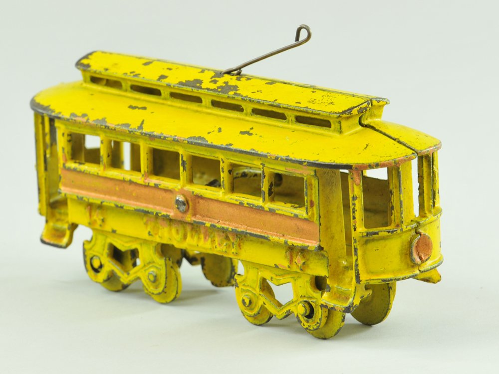KENTON TROLLEY: Kenton, scarce example, cast iron, painted in yellow w/red trimmed sides, features open cast benches, wheels allow pulling of toy. 7" l.
