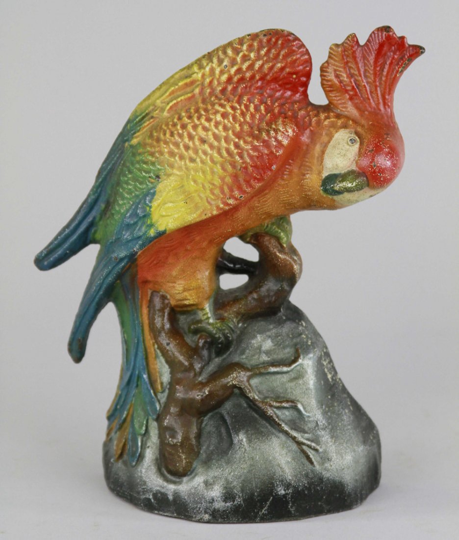 COCKATOO ON STUMP DOORSTOP: "L.A.C.S., 711," colorful cockatoo posed in downward dance motion, painted in bright red & orange hues with blue/green tail. BOOK EXAMPLE. 8 1/4" x 6 3/8".