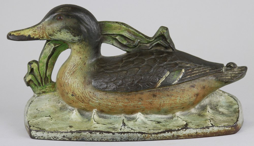 MALLARD DOORSTOP: Wonderful casting of mallard duck swimming through the bending marsh grass, excellent casting details, very desirable & rare. 11 3/4" x 6/12".