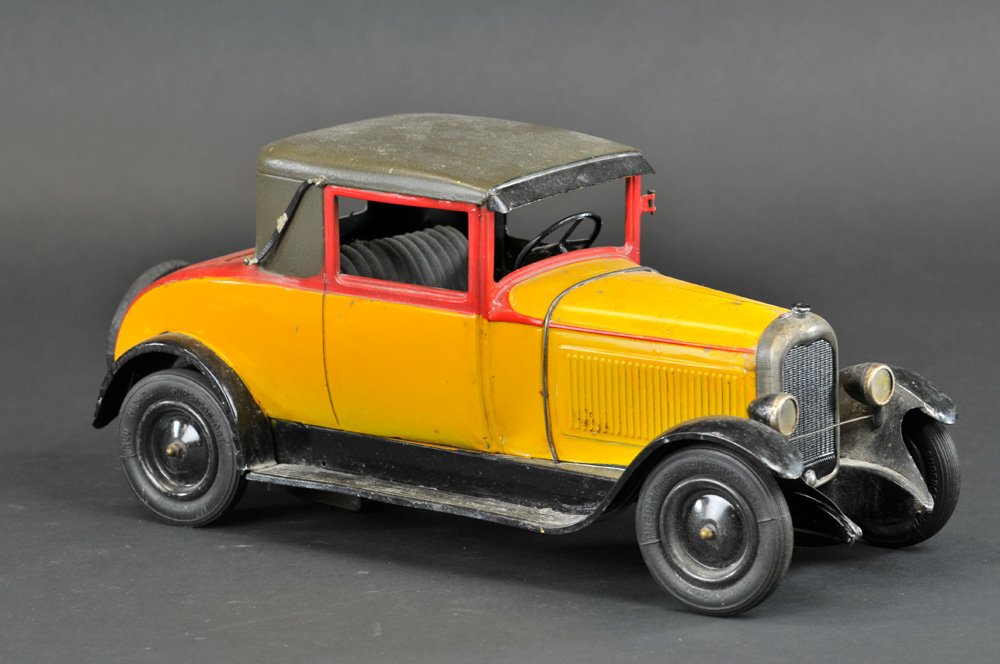 CITROEN C6 FAUX CABRIOLET: France, c. 1929, tin plate auto done in yellow body, red trunk highlights, dark green roof, black fenders, opening driver's door, rubber tires, clockwork driven. 15" l.