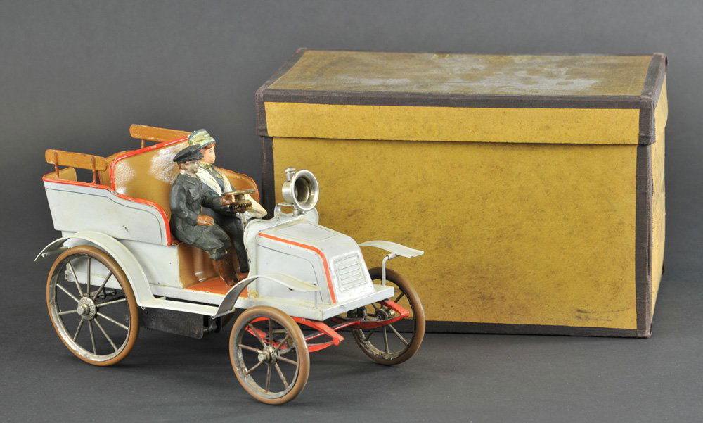 BOXED BING TONNEAU: Germany, c. 1903, hand painted tin auto, done in grey body, red striping, interior brown seats are embossed, front head lamp is nickeled, features spoke wheels, rubber tires, clockwork mechanism, and