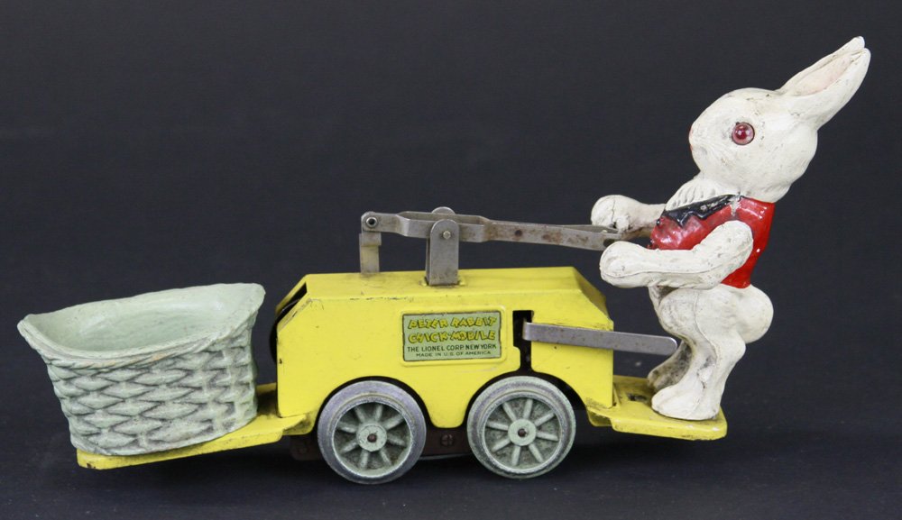 LIONEL PETER RABBIT CHICK MOBILE: Pressed steel yellow handcar, features composition painted figure of Peter Rabbit on one end, wicker basket on other, clockwork driven, train truck wheels. 10" l.