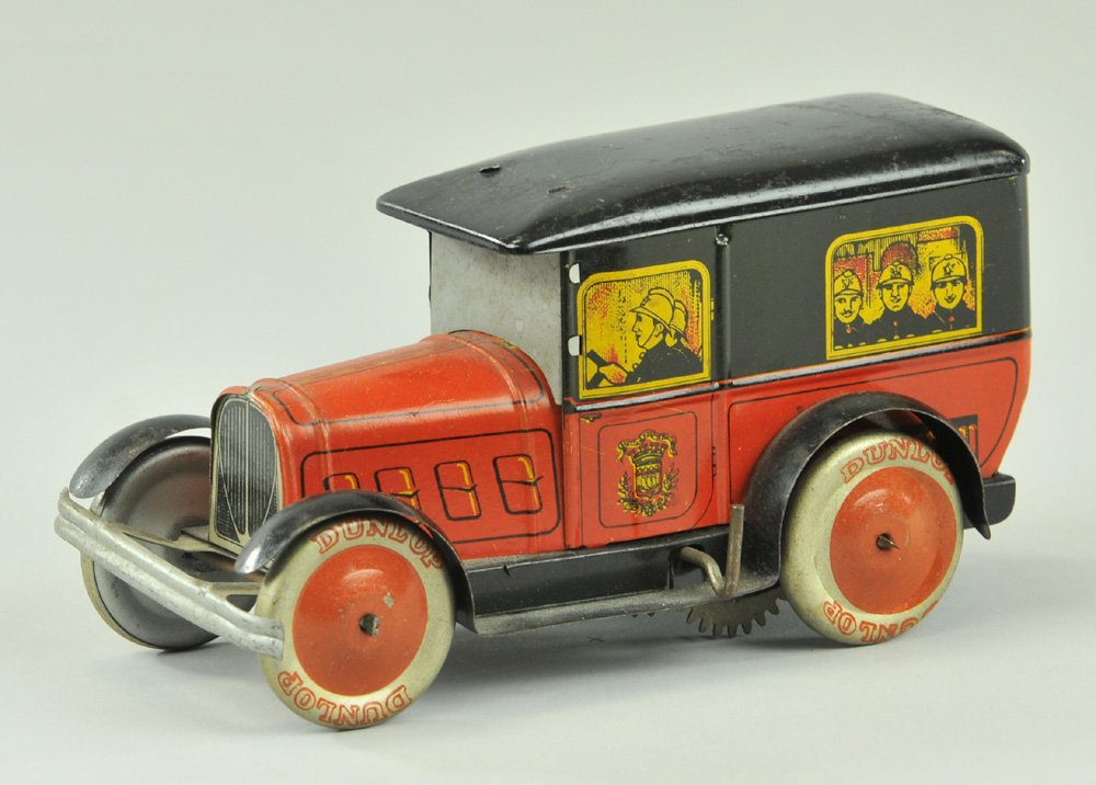 DEANDRIS FIRE TRUCK: 1930's, lithographed tin, red body, black opening roof, driver and seated fireman graphics at windows, key wind driven, disc wheels. 6 1/2" l.