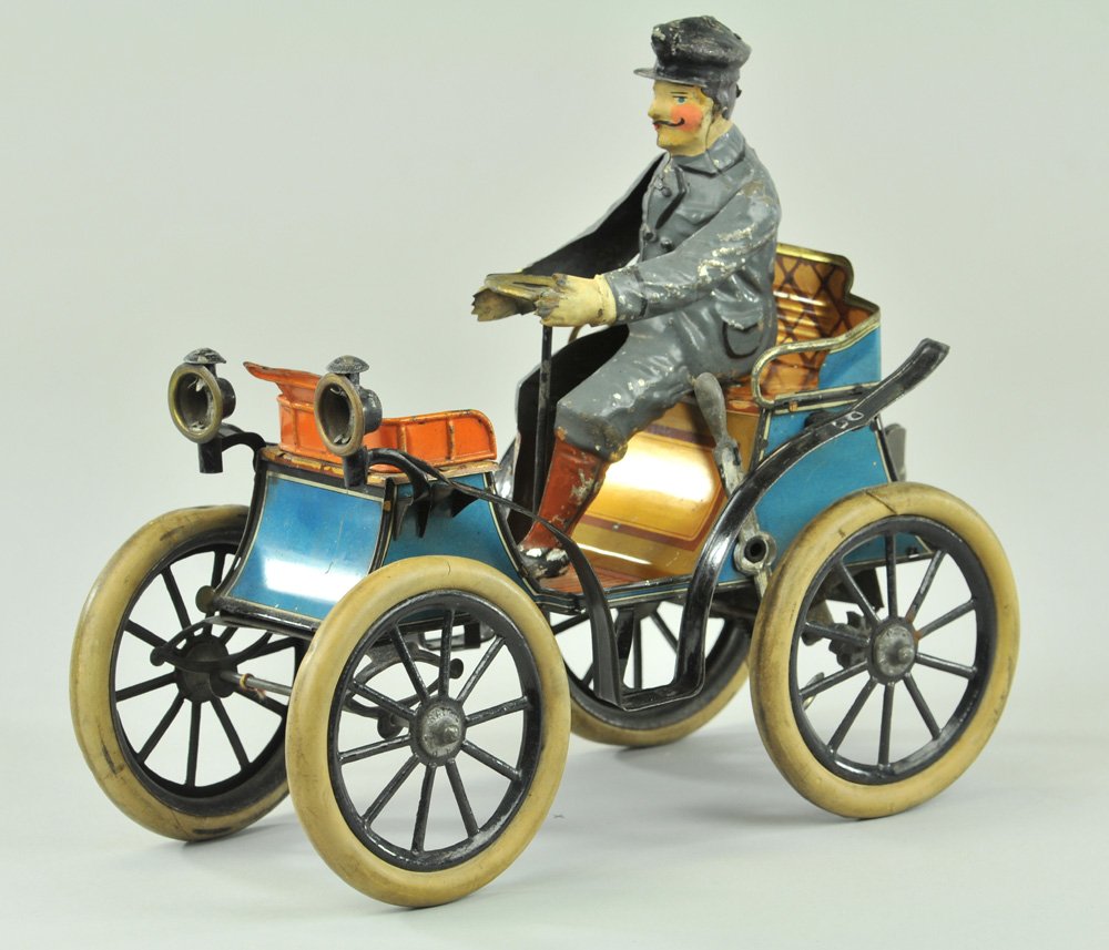 GUNTHERMANN VIS-À-VIS: Germany, c. 1895, large scale open auto w/hand painted original seated figure, lithographed tin body, headlamps on curved hood, rubber tires, spoke wheels. 9 3/4" x 3 3/4".