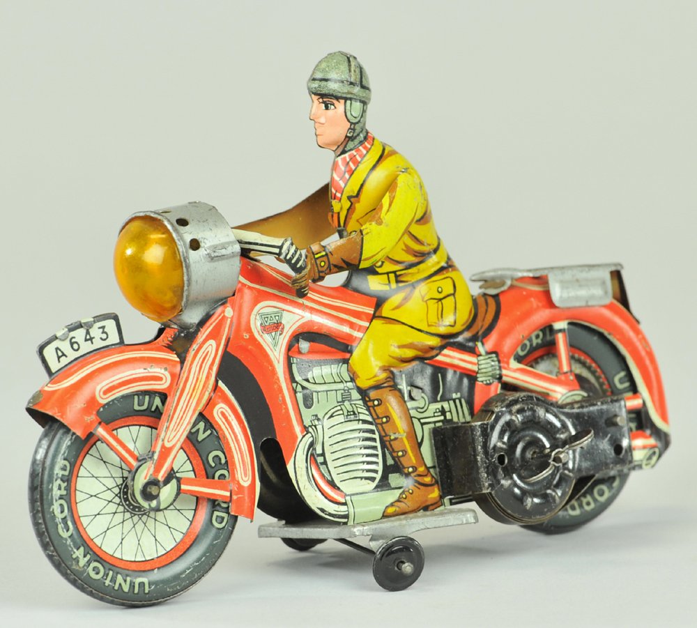 MAN RIDING MOTORCYCLE: Arnold, Germany, lithographed tin, done in red cycle, brown outfit, light at front, luggage rack on fender, key wind driven. 7 1/4" l.