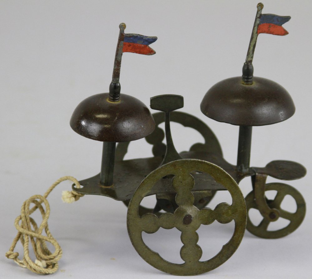 DOUBLE BELL TOY: Germany, pull toy features flag on each bell, center hammer rings both bells as it is pulled along, spoke wheels. 4 1/2" l.
