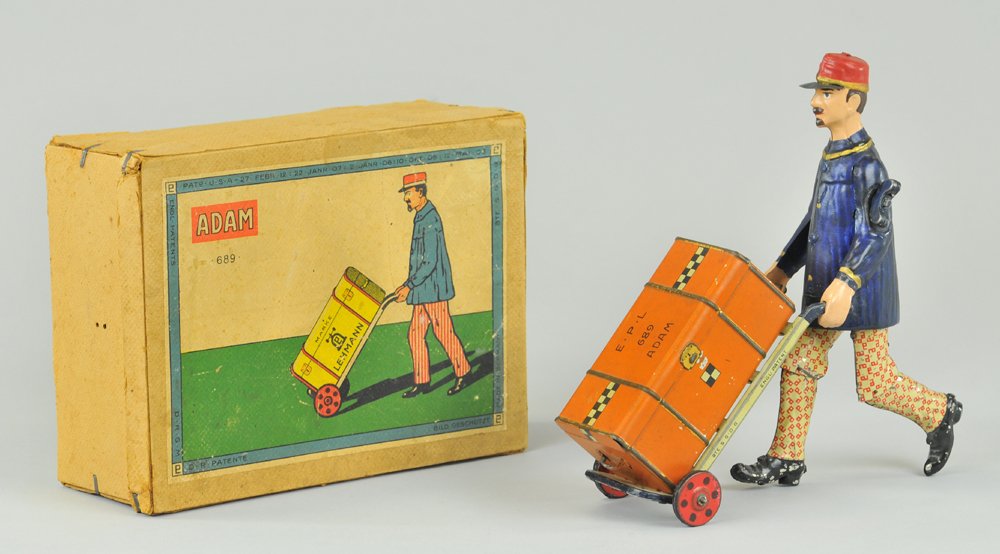 LEHMANN BOXED "ADAM" THE PORTER: Germany, lithographed and hand painted tin, familiar full figure in red Lehmann marked pants, blue jacket, red hat, pushes hand cart w/luggage, clockwork driven, great lid graphics. 8 1/4" h.