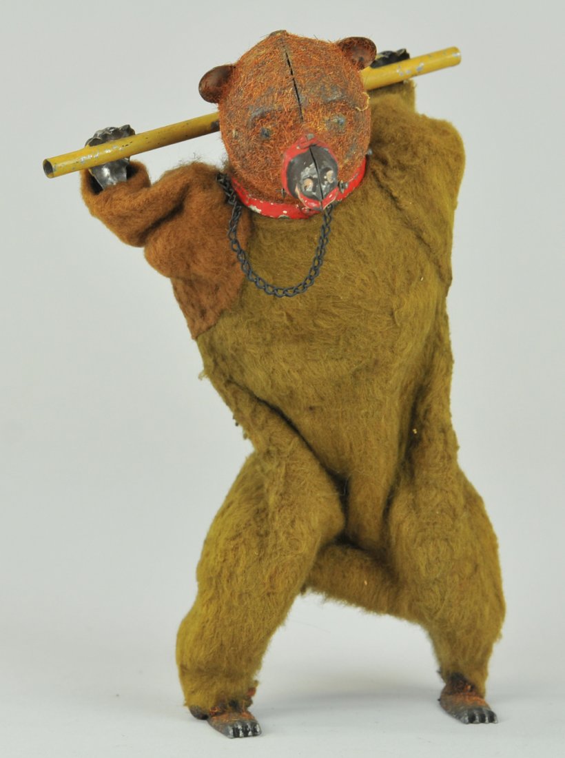 PERFORMING BEAR: Ferdinand Martin, France, tin bear outfitted in brown cloth simulated for body, holds bar on neck, features muzzle, clockwork mechanism. 7 1/2" h.