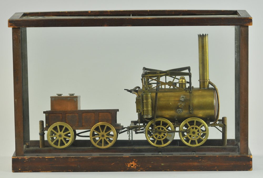 CONTEMPORARY STEAM LOCOMOTIVE AND TENDER: Brass model with side walking beams, tender made of wood, copper water tank in bed, very detailed piece, comes with one-piece track & display case, quite visual machining work, broken glass. Case 11" 