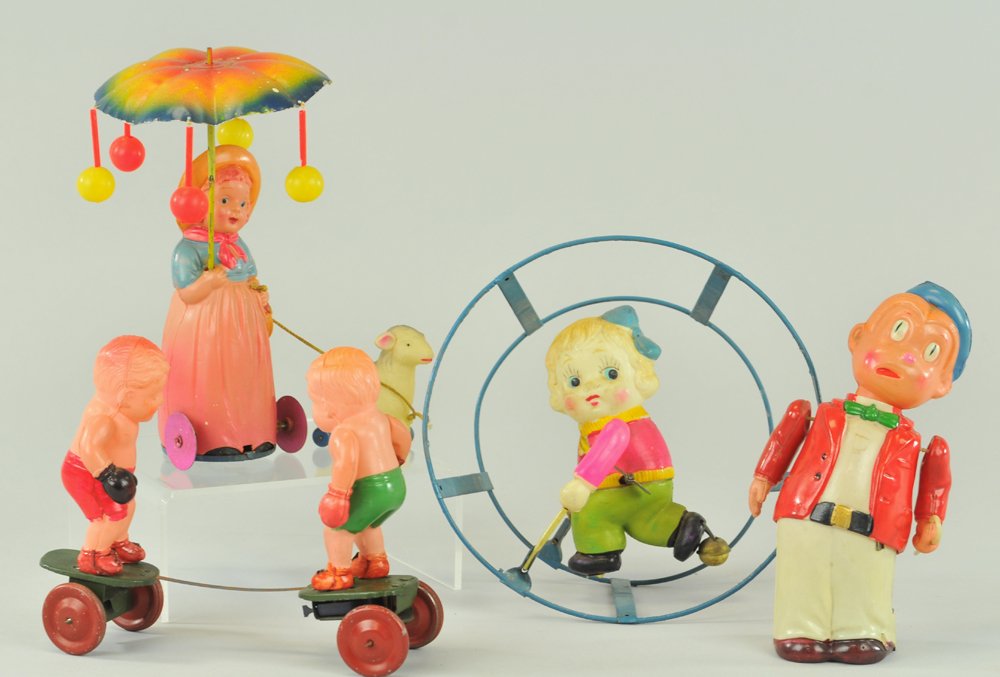 CELLULOID WHIMSICAL TOY LOT: Japan, very colorful grouping, includes: girl performing in wire hoop, girl in cowgirl outfit w/whirligig and holding lamb, amusing figure of man, and two boxers on tin wheeled platform, all key wind 