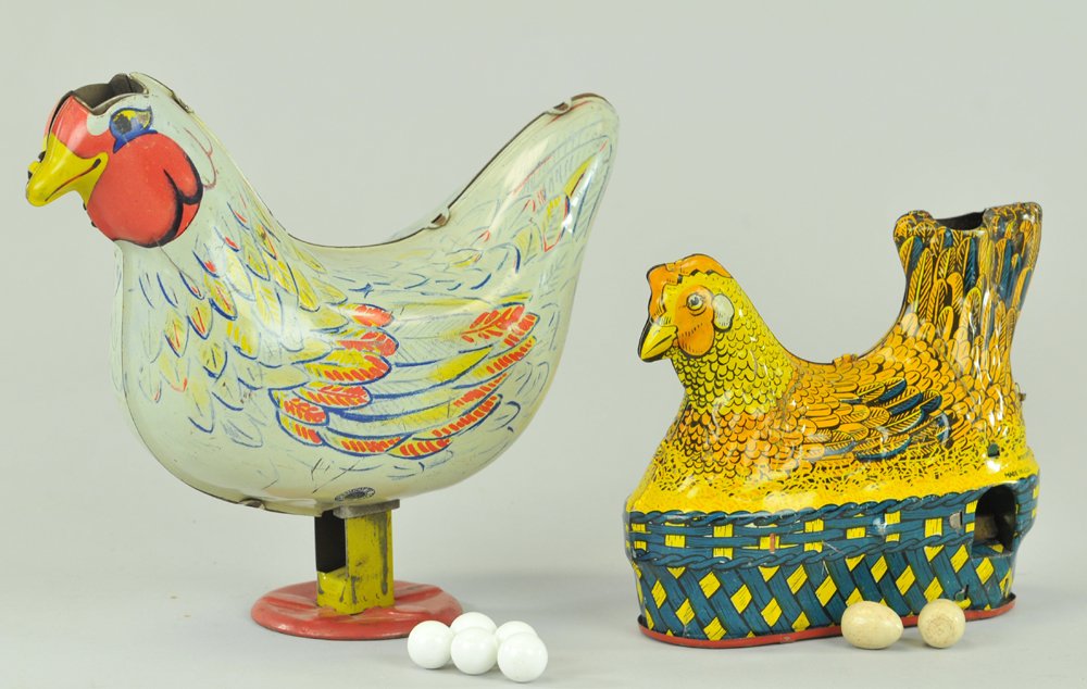 LOT OF TWO HEN LAYING EGGS TOYS: Both lithographed tin, one presses down to release eggs, made by Wyandotte, the other has turn lever, made by Baldwin, some wear at base. 5" - 7 1/2" l.