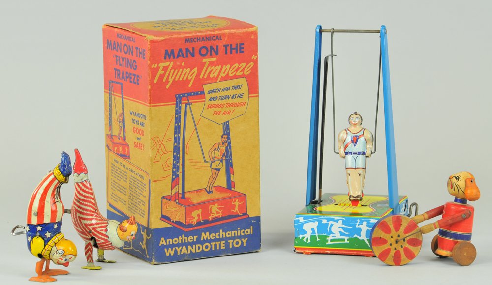 LOT OF TIN TOYS: Includes: Clown acrobat by Marx, Clown acrobat by Chein, Man on Trapeze bars w/original box by Wyandotte, and small wooden suited Dog in Cart toy. 3 1/2" - 9" h.
