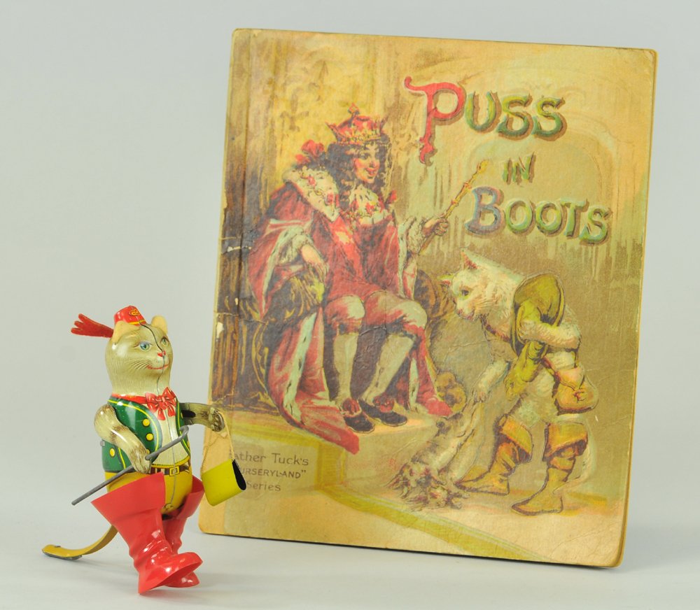 PUSS IN BOOTS TOY & BOOK: Includes tin lithographed walking toy, key wind driven, wears plastic boots, together with Father Tuck book. 5" h.