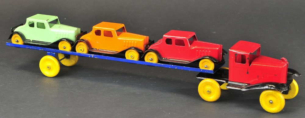 WYANDOTTE CAR CARRIER: c. 1936, pressed steel tractor and flat bed trailer with three original six inch Wyandotte cars, set appears in all original condition. 24" l.