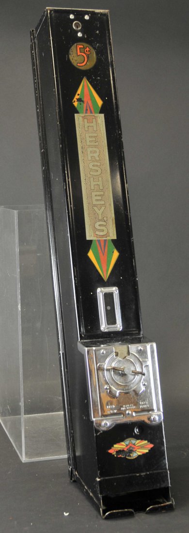 HERSHEY'S COIN OPERATED CANDY VENDING MACHINE: 5¢ dispensing machine, black metal case, decals on front, reads, "Hershey's," key included. 34" h. x 5" w.