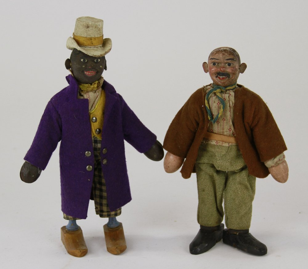 SCHOENHUT BLACK DUDE AND HOBO: Dude wears one-piece molded head, white top hat, purple overcoat, checked pants; Hobo in felt jacket, cloth pants, painted face, missing hat. 8 1/2" h.