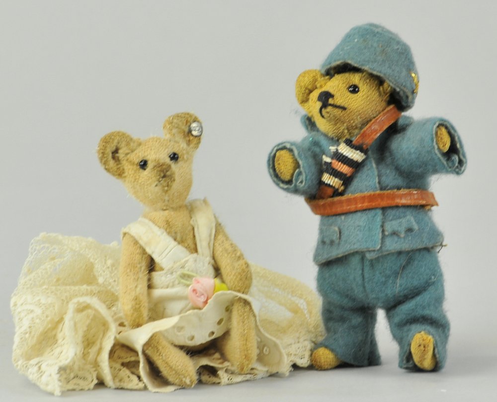 TWO COSTUME MINI STEIFF TEDDY BEARS: c. 1915, charming bears in hand made vintage costumes, Steiff bride and soldier, bears lacking mohair, one with button, underlined ff Steiff. 4" h.